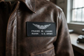 Pair of US Army black leather flight badges with custom stamped text for jackets and uniforms